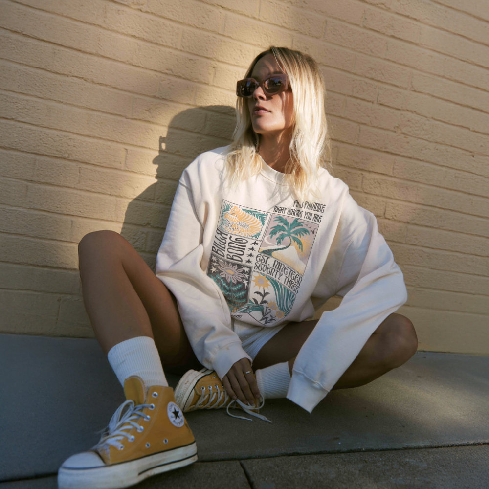 Hombre con campera outdoor organizando su mochila a orillas de un lago glaciar con montañas nevadas